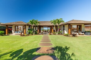 A modern two-story house with a covered patio, a well-maintained lawn, and a clear sky. - Hale Kipu by Alekona Kauai: Luxury 5br Ocean View Home w Pool, Fire pit, Spa (Koloa)