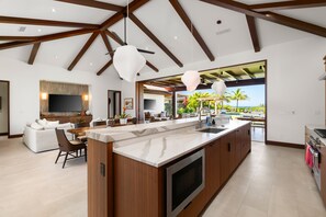 A modern kitchen with a large island, built-in appliances, and a view of the outdoors.