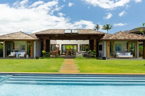A two-story house with a swimming pool in the foreground.