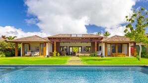 A resort with a swimming pool, two guest houses, and a central building with a covered patio. - Hale Kipu by Alekona Kauai: Luxury 5br Ocean View Home w Pool, Fire pit, Spa (Koloa)