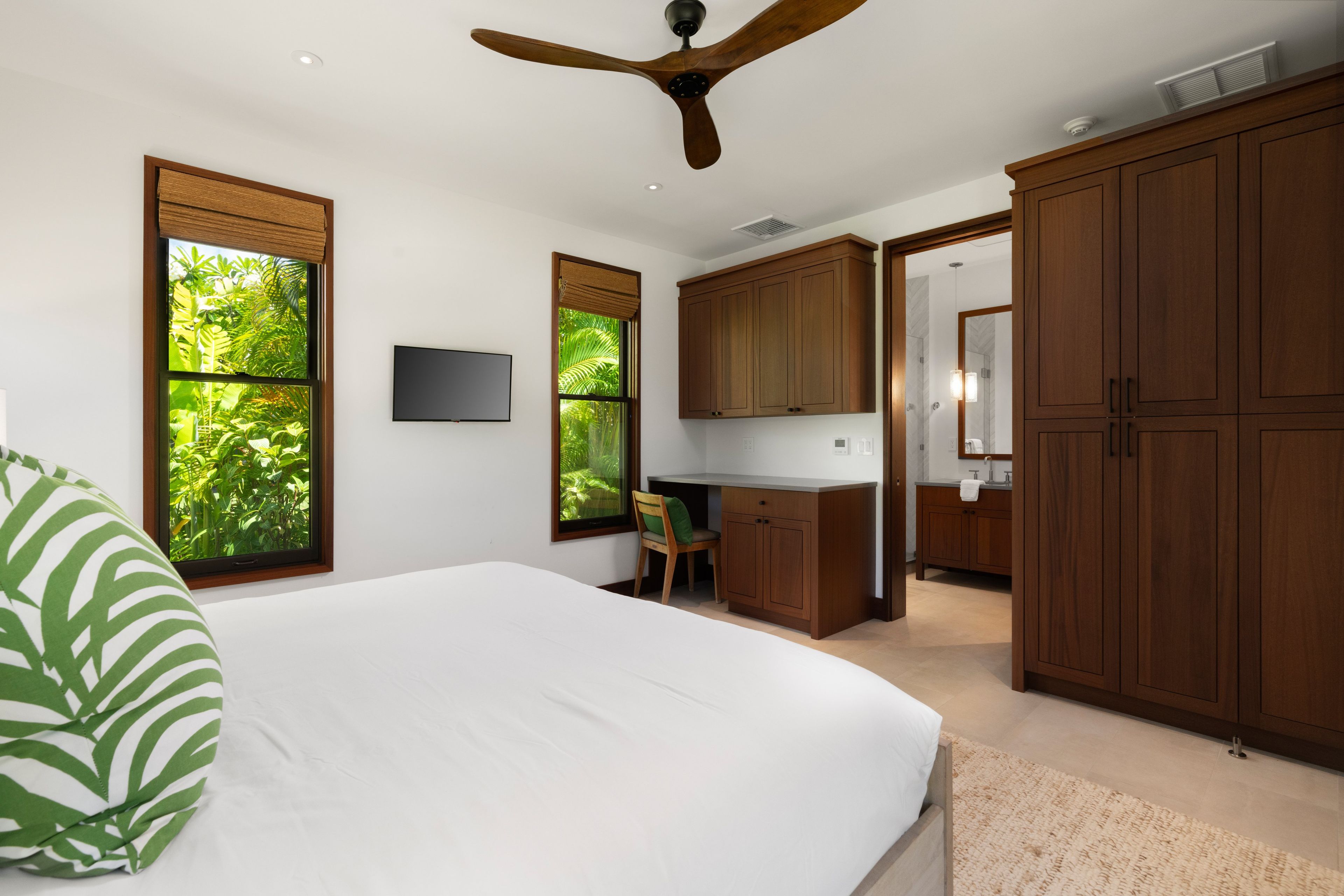A bedroom with a bed, a desk, and a wardrobe.