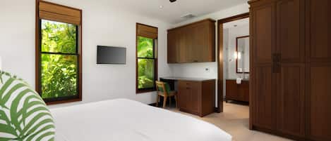A bedroom with a bed, a desk, and a wardrobe.