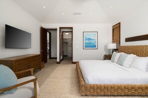 A bedroom with a large bed, a television on the wall, a desk, and a wardrobe. - Hale Kipu by Alekona Kauai: Luxury 5br Ocean View Home w Pool, Fire pit, Spa (Koloa)