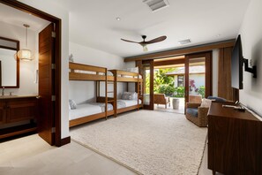 A modern bedroom with bunk beds, a desk, and a TV. - Hale Kipu by Alekona Kauai: Luxury 5br Ocean View Home w Pool, Fire pit, Spa (Koloa)