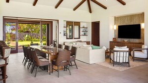 A spacious living area with a dining table, sofas, and a TV. - Hale Kipu by Alekona Kauai: Luxury 5br Ocean View Home w Pool, Fire pit, Spa (Koloa)