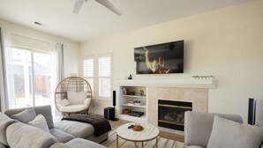 A modern living room with a sofa set, a round coffee table, a fireplace, and a mounted TV. - NEW Roomy Upscale, Mt. Rose Ski/Tahoe 25-Min, XL Sofa and 2 Work Desks  (Reno)