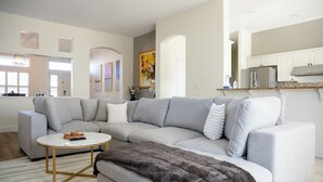 A modern living room with a grey sectional sofa, a round coffee table, and a fur throw. - NEW Roomy Upscale, Mt. Rose Ski/Tahoe 25-Min, XL Sofa and 2 Work Desks  (Reno)