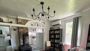 Een gezellige woonkamer met een bank, een bijzettafeltje, een open haard en een boekenkast.