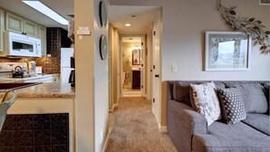 A compact living space with a kitchenette, a sofa, and a hallway leading to a bathroom. - Beautiful views! Sleeps 2, Indoor Pool (Gatlinburg)