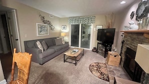 A living room with a sofa, coffee table, fireplace, and a television. - Beautiful views! Sleeps 2, Indoor Pool (Gatlinburg)