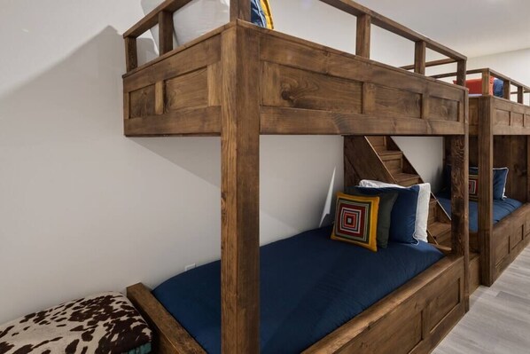 Un lit superposé avec une structure en bois et une literie bleue.