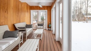 A wooden deck with wicker furniture and a white ceiling fan. - Riverbend Retreat: A Three-Story Haven in Stowe (Stowe)