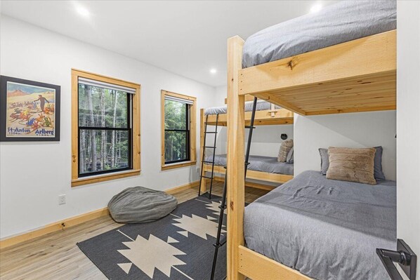 A bunk bed room with a window, a poster, and a rug. - Stowe Serenity Lodge - Minutes to the Mountain (Stowe)