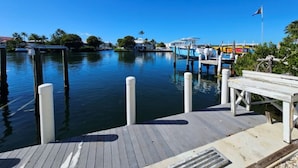 A marina with docked boats, a wooden dock, and a clear blue sky.