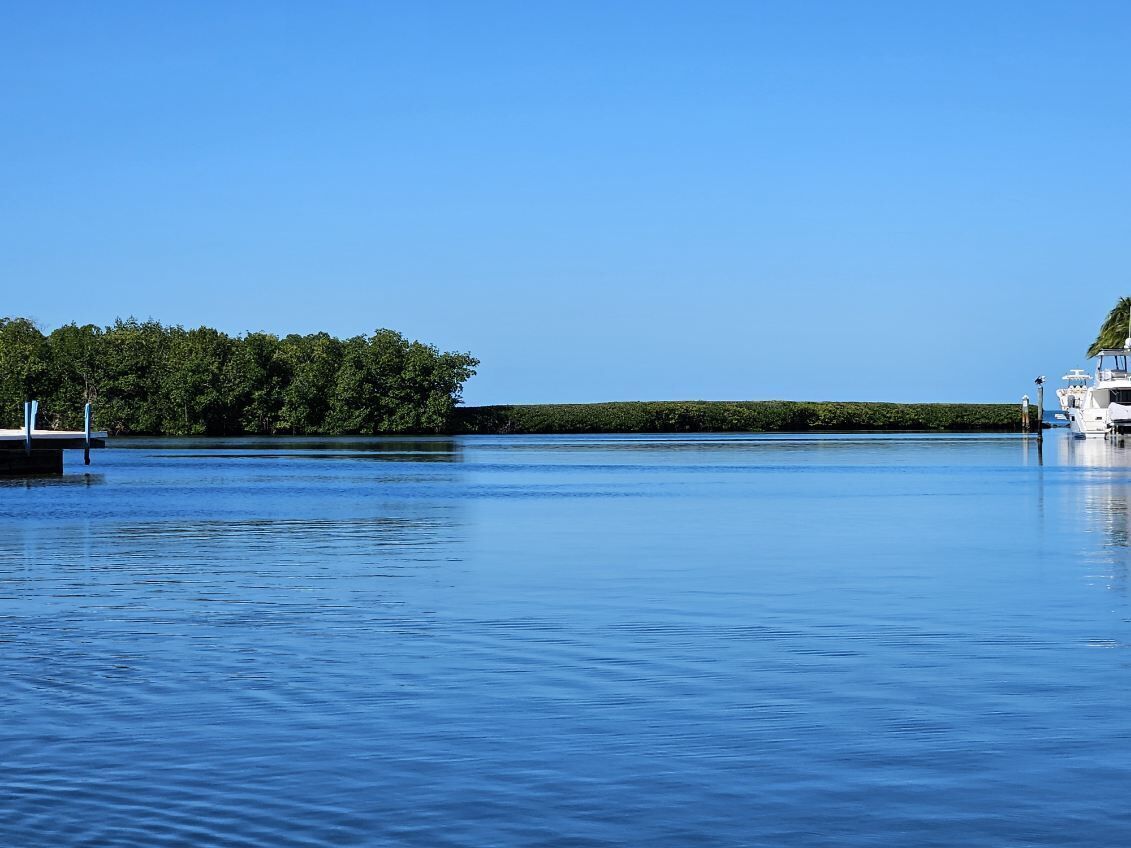 A calm lake with a dock and a boat on the right.