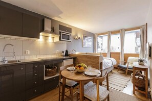 Una cucina moderna con zona pranzo, mobili in legno e ampie finestre.