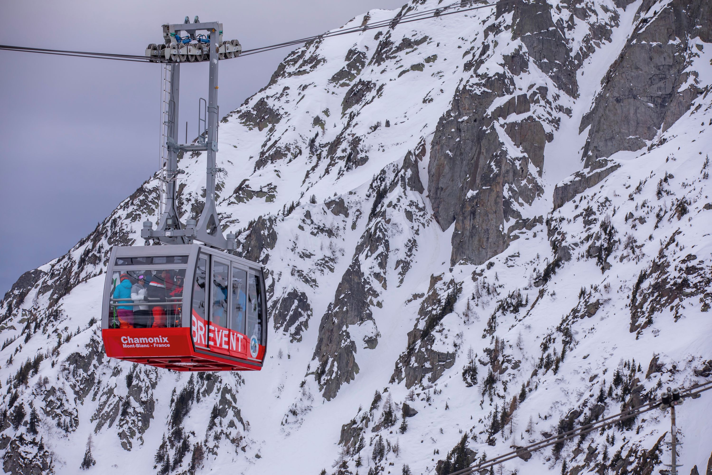 Eine Sesselbahn mit "BRIEVENT"-Branding, die einen schneebedeckten Berg hinaufsteigt.