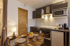 Una cocina compacta equipada con microondas, cafetera y lavavajillas.