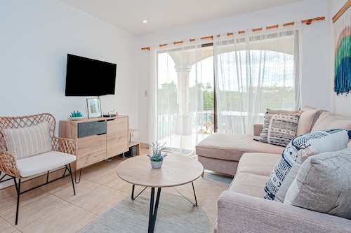 Modern condo near beaches with mountain views, outdoor pool, balcony, W/D, AC