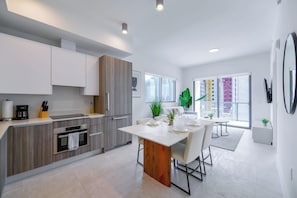 Una cocina moderna con comedor, ventanas amplias y vistas a edificios.