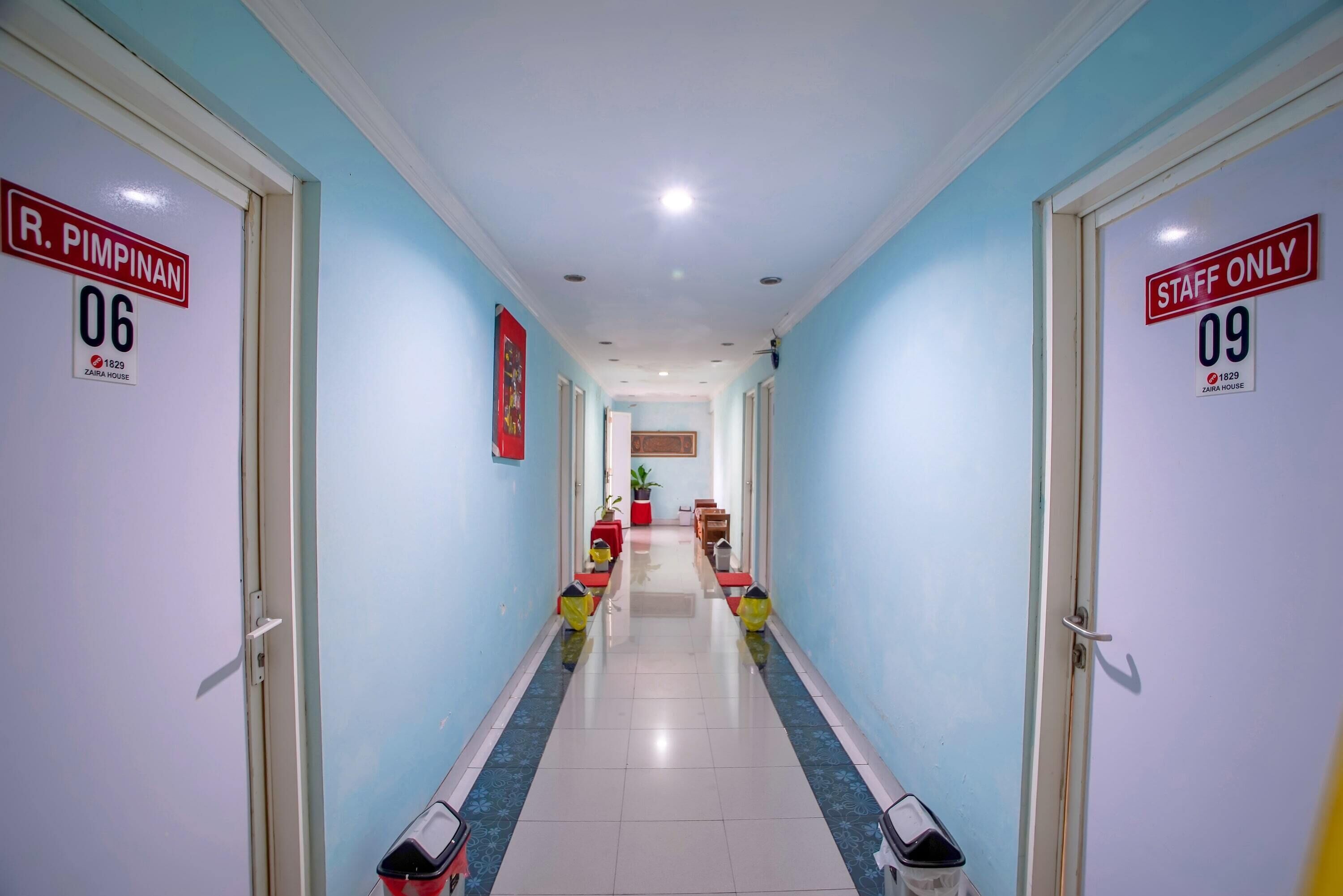 A hotel corridor with doors labeled "R. PIMPINAN 06" and "STAFF ONLY 09".