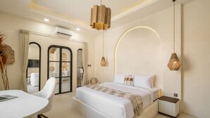 Una habitación de hotel moderna con una cama grande, un escritorio y una zona de estar.