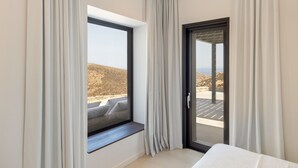 Ein modernes Hotelzimmer mit großem Fenster und einer Schiebetür zu einem Außenbereich.