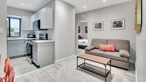 Een modern appartement met keuken, woonruimte en een bank.