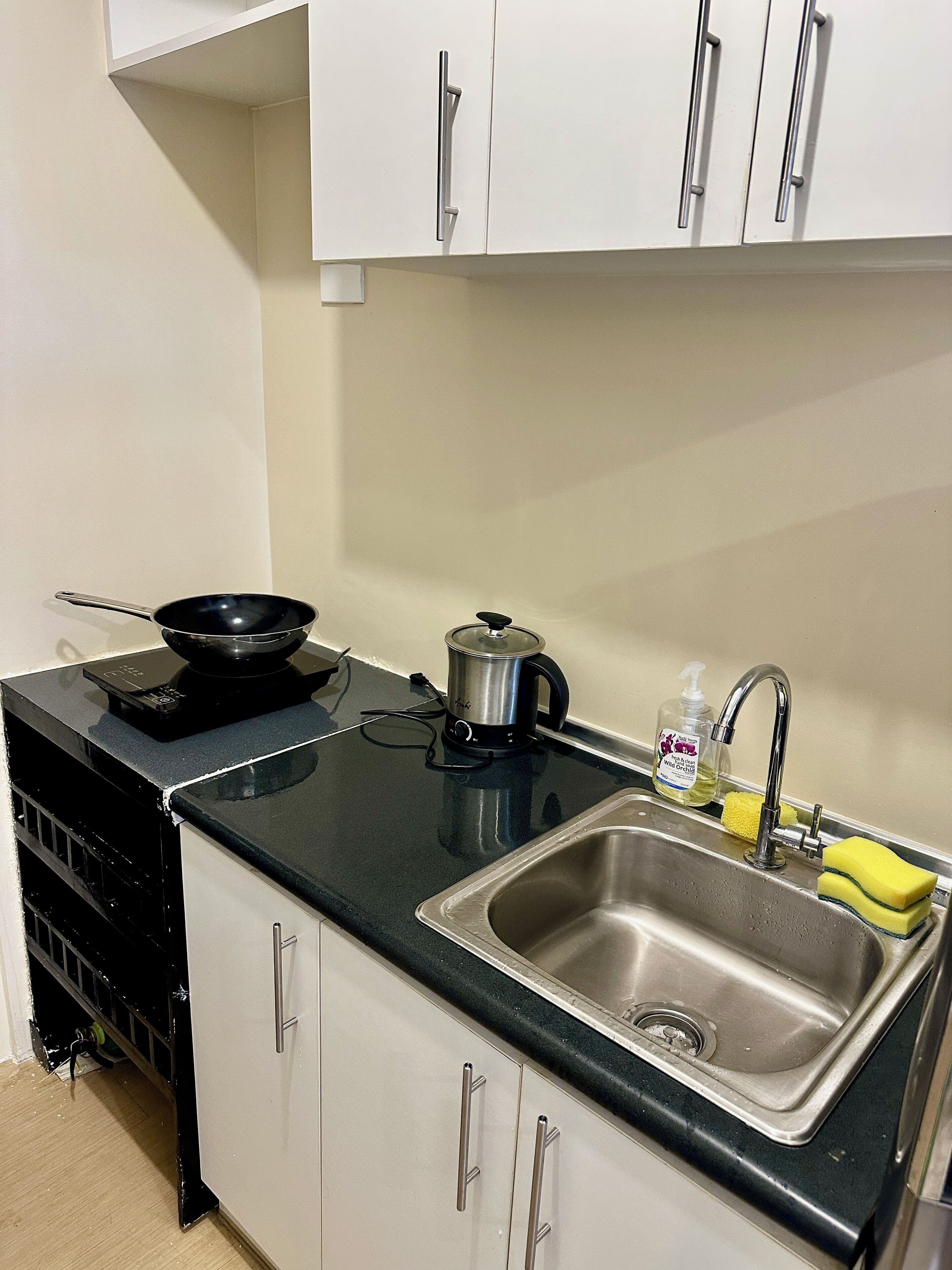 A compact kitchen with a sink, stove, and cabinets.