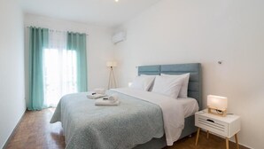 A modern bedroom with a bed, bedside table, and a lamp.
