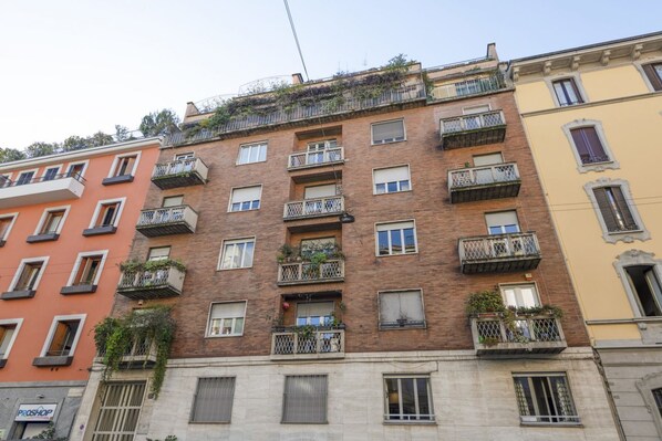 A multi-story building with balconies, windows, and a visible storefront.