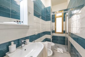 A bathroom with a large sink, a toilet, and a shower area. - BnButler - Maloja, 10 (Milano)