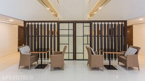 A lobby with a reception desk, four wicker chairs, and a modern interior design. - Elegant One-Bedroom Haven with Multiple Views at Cebu IT Park (Cebu City)