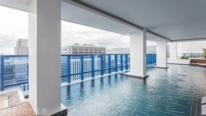 An indoor swimming pool with a view of city buildings. - Elegant One-Bedroom Haven with Multiple Views at Cebu IT Park (Cebu City)