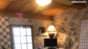 A cozy room with a bed, a desk, a lamp, and a fireplace.