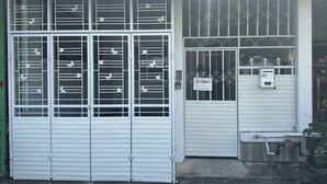 Een gebouw met een grote, witte entree van metaal, versierd met decoratieve vlindermotieven.