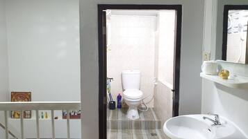A bathroom with a toilet, sink, and shower.