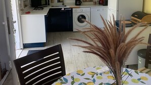 Eine kleine Küche mit Waschmaschine, Mikrowelle und Kaffeemaschine.