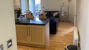 A modern kitchen with wooden cabinets, a central island, and a dining area with chairs.