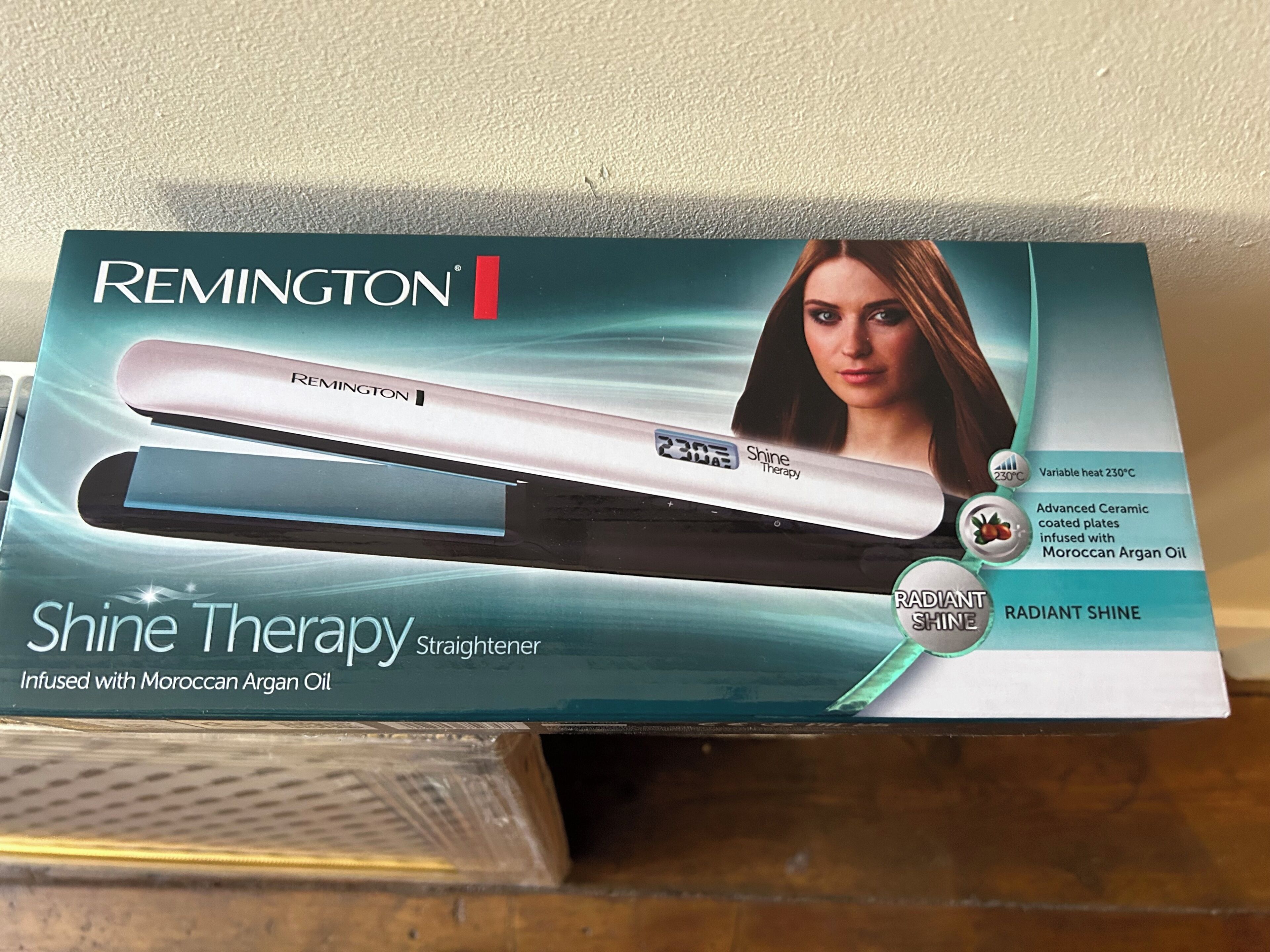 Una caja de plancha para el cabello Remington Shine Therapy con aceite de argán marroquí.