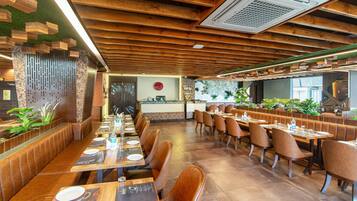 Un restaurante con vigas de madera en el techo, una recepción y cabinas con asientos de cuero marrón.
