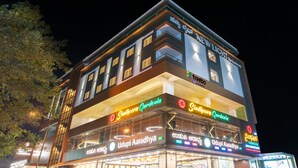 A multi-story building with various shops on the ground floor, including a restaurant named 'Sindhcoora Cardenia'.