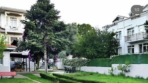 Una zona residenziale caratterizzata da un prato curato, un vialetto e una panchina.