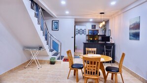 Un espace de vie moderne comprenant un coin repas, une cuisine et un escalier.