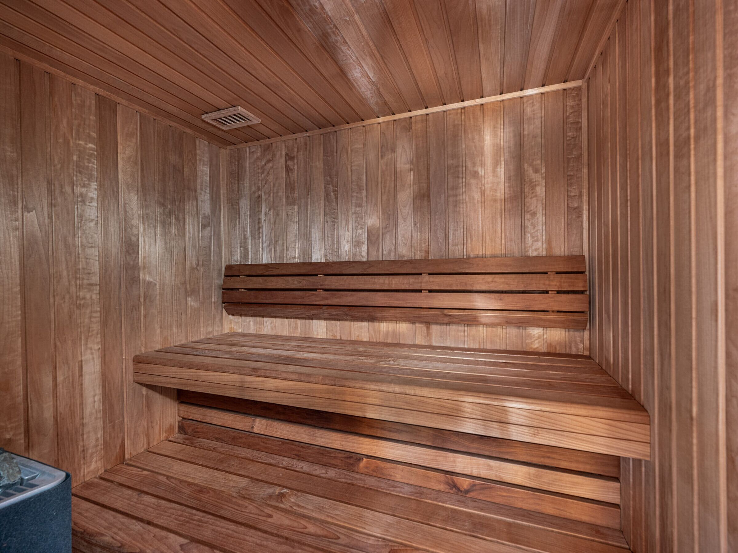 Un sauna avec des murs et des bancs en bois.