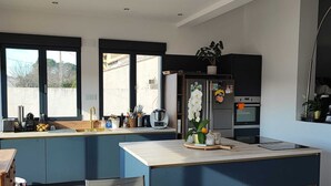 A modern kitchen with a central island, built-in appliances, and large windows.