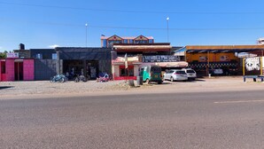 Zona comercial con diversas tiendas, entre ellas una peluquería, un restaurante de barbacoa y una cafetería.