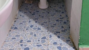 Un baño pequeño y estrecho con inodoro, lavamanos y ventana.