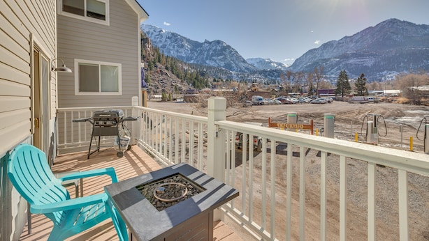 A balcony with a grill, chairs, and a view of mountains. - Spacious Ouray Townhome - Walk to Hot Springs! (Ouray)