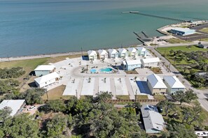 An aerial view of a coastal hotel with multiple buildings, a swimming pool, and a pier. - Ahoy Matey Sp151 4 Bedroom Home by RedAwning (Fulton)